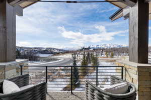 Snow covered back of property with a mountain view