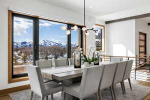 Dining room featuring a mountain view, a notable chandelier, recessed lighting, wood finished floors, and baseboards