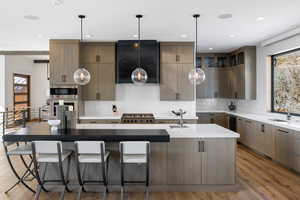 Kitchen featuring an island with sink, modern cabinets, and light countertops