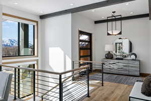 Hallway featuring recessed lighting, a mountain view, an upstairs landing, wood finished floors, and beamed ceiling