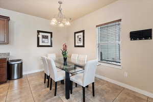 Dining area with baseboards, a wealth of natural light, and light tile patterned flooring