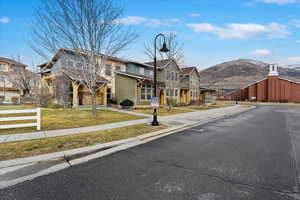 View of street with sidewalks, a residential view, a mountain view, and street lights