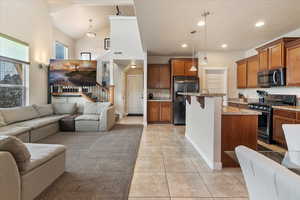 Kitchen with open floor plan, gas range oven, and stainless steel microwave