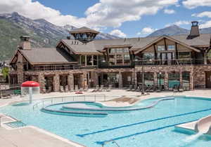 Pool featuring a water slide, a patio area, a fence, and a mountain view