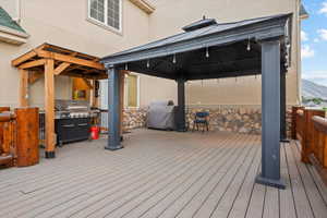 Deck with a mountain view, area for grilling, and a gazebo