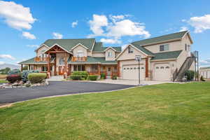 View of front facade with a front yard, driveway, stairway, and stucco siding