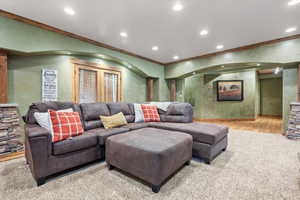 Living room featuring light wood finished floors, crown molding, and recessed lighting