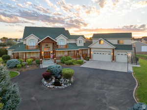 View of front facade with an attached garage, covered porch, concrete driveway, roof with shingles, and stucco siding