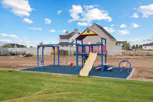 View of jungle gym featuring a yard and fence