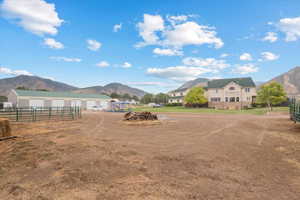 View of yard featuring an outbuilding, fence, a mountain view, and a garage