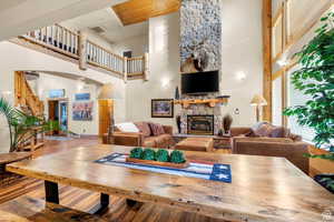 Living area featuring a fireplace, stairway, a high ceiling, and wood finished floors