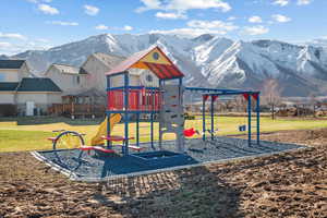 Community playground with a yard and a mountain view