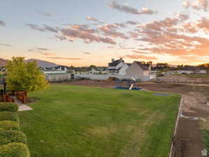 Yard at dusk featuring playground community and a residential view