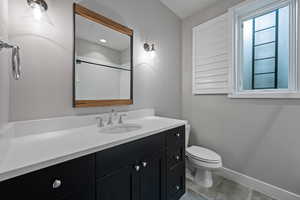 Bathroom with vanity, toilet, and a shower