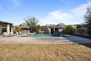 View of swimming pool with a yard, a pergola, and a patio area