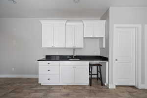 Kitchen featuring sink, dark wood-type flooring, and white cabinets