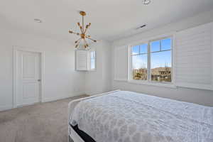 Carpeted bedroom with a notable chandelier