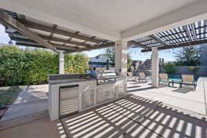 View of patio / terrace featuring a fenced in pool, a grill, area for grilling, and a wet bar