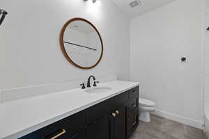 Bathroom featuring tile patterned floors, vanity, and toilet