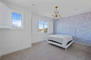 Bedroom featuring carpet floors and an inviting chandelier