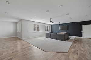 Unfurnished living room with light hardwood / wood-style flooring and ceiling fan