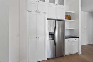 Kitchen featuring white cabinetry, stainless steel refrigerator with ice dispenser, and light wood-type flooring