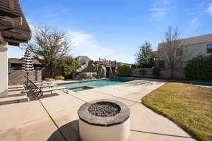 View of pool with a patio area and an outdoor fire pit