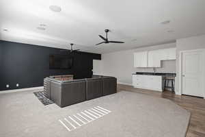 Living room with sink, ceiling fan, and light hardwood / wood-style floors