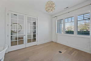 Unfurnished room with light hardwood / wood-style floors and french doors