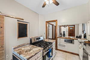 Kitchen with ceiling fan, stainless steel appliances, and white cabinets