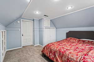 Bedroom with vaulted ceiling and light colored carpet