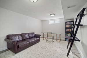 Living room with baseboards, visible vents, and a textured ceiling