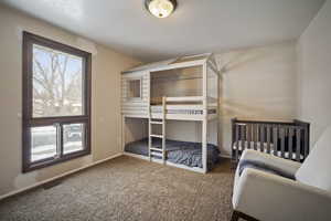 Carpeted bedroom featuring baseboards and visible vents