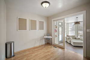 Foyer entrance with visible vents, baseboards, and wood finished floors