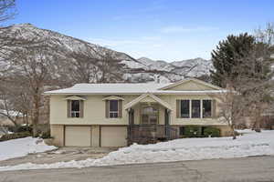 Split foyer home featuring an attached garage, a mountain view, and brick siding