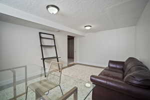 Living room featuring a textured ceiling and baseboards