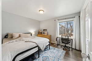 Bedroom with dark wood finished floors and baseboards