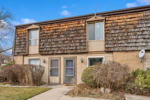 Townhome / multi-family property with mansard roof and brick siding