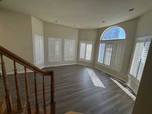 Interior space featuring dark hardwood / wood-style floors, a textured ceiling, and a healthy amount of sunlight