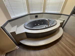 Master Bath featuring a bath, hardwood / wood-style flooring, and a hot tub