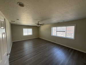 Master bedroom with ceiling fan, a textured ceiling, and dark hardwood / wood-style flooring