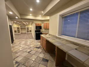 Kitchen featuring tile counters and black appliances