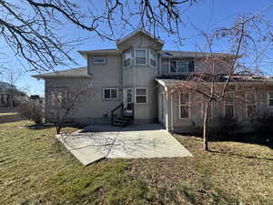 Back of property with a yard and a patio area