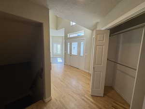 Interior space featuring light hardwood / wood-style flooring, vaulted ceiling, and a textured ceiling