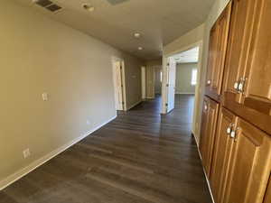 Hall featuring a textured ceiling and dark hardwood / wood-style floors