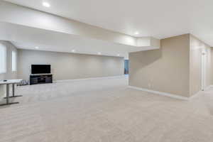 Below grade area featuring baseboards, recessed lighting, and light colored carpet