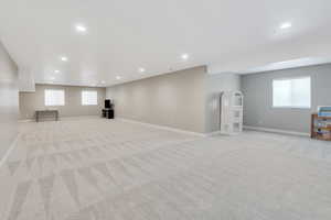 Below grade area featuring recessed lighting, light colored carpet, and baseboards