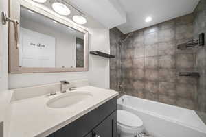 Full bathroom with washtub / shower combination, vanity, and toilet