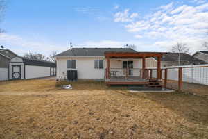 Back of house with an outbuilding, a yard, a wooden deck, a pergola, and a shed