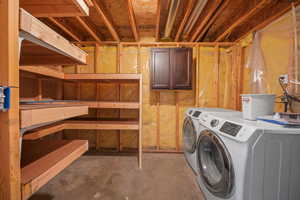 Clothes washing area featuring laundry area and washer and clothes dryer